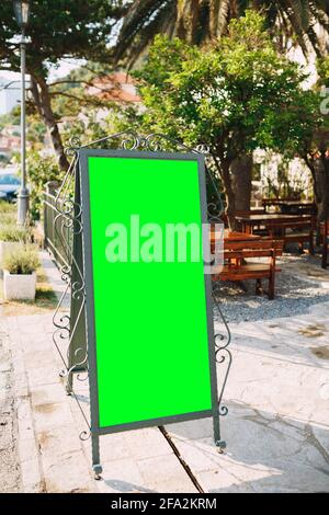 HolzStaffelei in einem schönen geschmiedeten Metallrahmen mit einem Vor dem Eingang zum steht ein leeres Feld Restaurant Stockfoto