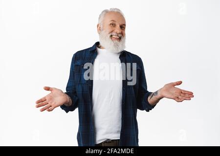 Ich weiß es nicht. Gutaussehender alter Mann lachend und zuckend Schultern ahnungslos, kann nichts sagen, haben keine Ahnung, stehen verwirrt und nicht bewusst gegen Weiß Stockfoto