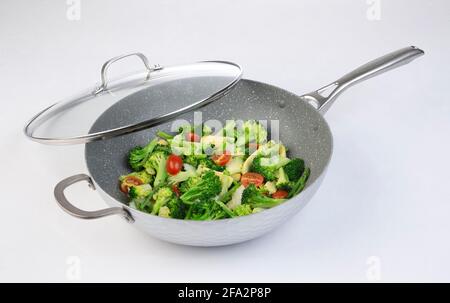 Bratpfanne mit gebratenem Gemüse und Glasdeckel isoliert Weißer Hintergrund Stockfoto