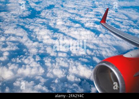 Blick auf Wolken und Flügel aus einem Flugzeugfenster Stockfoto