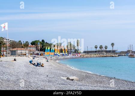 Cagnes-sur mer, FRANKREICH - 25.03.2021. Blick auf das Meer an einer Küste mit Hafen, Palmen und Gebäuden. Stockfoto