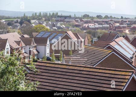 Solarpaneele auf den Dächern von Neubauten in Pinhoe Exeter, Devon. Neue Wohnungen, nachhaltige Energiequellen. Hausgebäude. Stockfoto