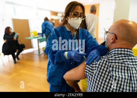 Barcelona, Spanien - 4. april 2021: Eine Krankenschwester mit Spritze, die einer älteren Person in der Klinik einen Covid19- oder Coronavirus-Impfstoff verabreicht. Impfkampagne und Jab Stockfoto