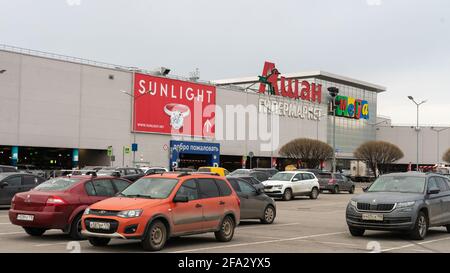 Der Parkplatz in der Nähe von Auchan (auf Russisch oder kyrillisch) in MEGA Dybenko, einem großen Supermarkt St. Petersburg, Russland Stockfoto