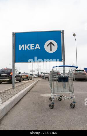 Verlassene Einkaufswagen oder Trolley in der Nähe von direktionalen IKEA-Schild auf der Straße in Russisch oder Kyrillisch in St. Petersburg, Russland Stockfoto