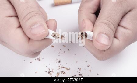 Zerbrochene Zigarette in der Hand aus der Nähe, hören Sie auf zu rauchen. Stockfoto