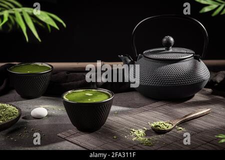 Matcha-Teepulver und Tee-Accessoires auf dunklem Hintergrund. Teezeremonie. Traditionelles japanisches Getränk. Stockfoto
