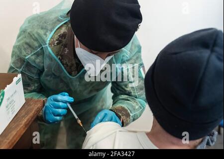 Ein Mitglied der medizinischen Task Force der italienischen Armee verwaltet den Impfstoff Pfizer-BioNTech, Covid19, an einen älteren Bürger in Longobuco. Eine mobile Gesundheitseinheit der italienischen Armee erreichte Longobuco, ein abgelegenes Dorf im Sila-Nationalpark, um das Covid-19-Impfprogramm für behinderte und ältere Menschen über 80 Jahren durchzuführen. Nach dem Anstieg der Covid19-Fälle in der Region begann die medizinische Task Force der italienischen Armee zusammen mit der Provincial Health Authority (ASP) von Cosenza und Freiwilligen von Misericordia, Pfizer/BioNTech-Impfstoff an die gefährdeten Menschen in der Region zu liefern Stockfoto