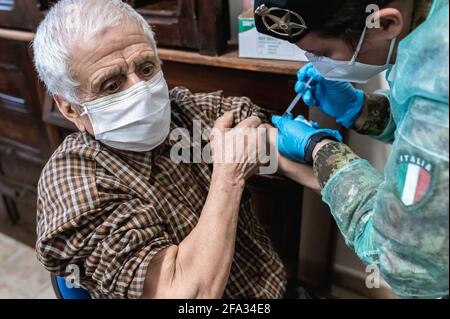 Ein Mitglied der medizinischen Task Force der italienischen Armee verwaltet den Impfstoff Pfizer-BioNTech, Covid19, an einen älteren Bürger in Longobuco. Eine mobile Gesundheitseinheit der italienischen Armee erreichte Longobuco, ein abgelegenes Dorf im Sila-Nationalpark, um das Covid-19-Impfprogramm für behinderte und ältere Menschen über 80 Jahren durchzuführen. Nach dem Anstieg der Covid19-Fälle in der Region begann die medizinische Task Force der italienischen Armee zusammen mit der Provincial Health Authority (ASP) von Cosenza und Freiwilligen von Misericordia, Pfizer/BioNTech-Impfstoff an die gefährdeten Menschen in der Region zu liefern Stockfoto