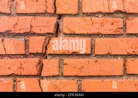 Riss auf alten braunen beschädigten Ziegelwand gebrochene Fassade Textur Hintergrund. Stockfoto