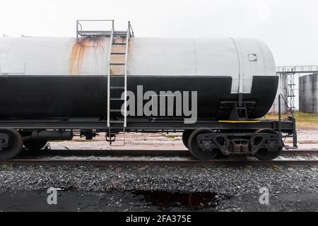 Verschmutzter Eisenbahntankwagen mit Düngemitteln oder chemischen Produkten nach dem Entladen in einem Industriewerk. Stockfoto
