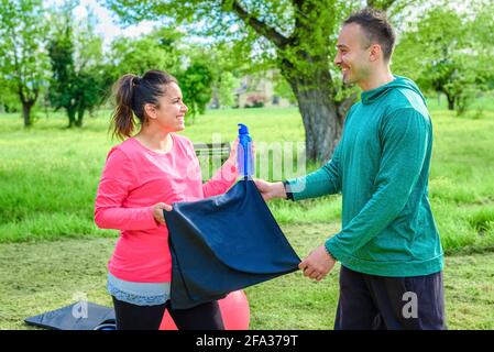 Ein paar lächelnde Personal Trainer und eine schöne Frau, die Workout-Übung im Freien in einem park.friends Interaktion nach dem Fitness-Studio Sitzung draußen. Fit Stockfoto