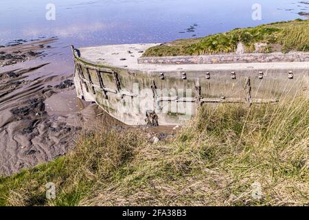Ein Betonkahn, eines von vielen Schiffen, wurde absichtlich an den Ufern des Flusses Severn befahren, um die Erosion auf dem Friedhof der Purton-Hulks oder Schiffe zu verhindern. Stockfoto