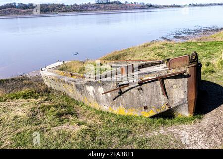 Ein Betonkahn, eines von vielen Schiffen, wurde absichtlich an den Ufern des Flusses Severn befahren, um die Erosion auf dem Friedhof der Purton-Hulks oder Schiffe zu verhindern. Stockfoto