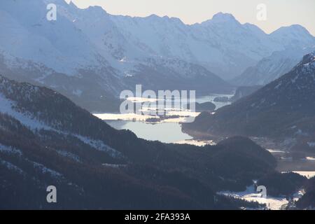 Luftaufnahme des halbgefrorenen Flusses, umgeben von Bergen bedeckt Im Winter im Schnee Stockfoto