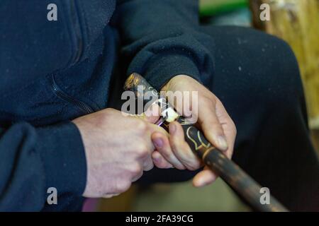 Der Mensch ist ein ländliches Ungarn, Hortobagy arbeitet an einer traditionellen ungarischen, handgefertigten Hirtenpeitsche Stockfoto