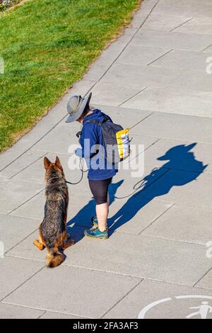 Frau, die mit ihrem Schäferhund am Steveston steht Waterfront in British Columbia, Kanada Stockfoto