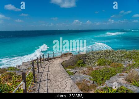 Isla Mujeres South Point Punta Sur Cancun Mexico Island türkisfarbenes Wasser und Weg zur felsigen Küste, Hintergrund blauer Himmel Stockfoto