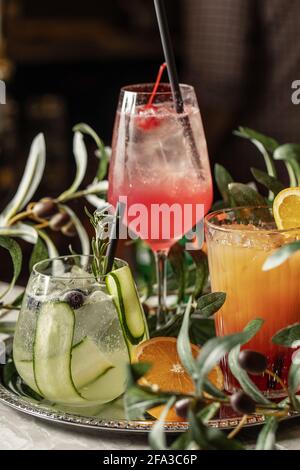 Gin Tonic Cocktail mit Gurke, Aperol Spritz Orangencocktail mit Orangenscheiben auf silbernem Tablett Stockfoto