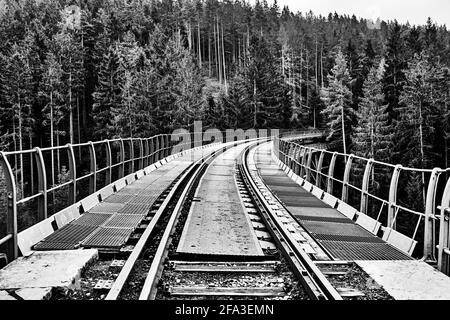 Schwarz-Weiß-Foto einer historischen Brücke über das Ziemestal in Thüringen mit einer stillgesteppten Eisenbahnlinie. Stockfoto