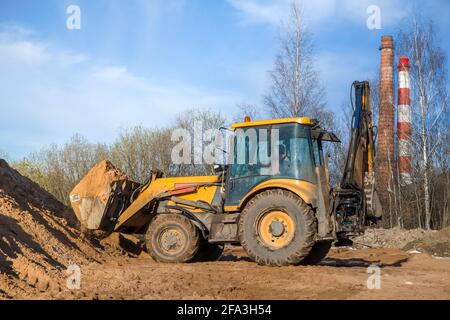 Traktor mit Sand im Eimer an einem klaren Tag Und blauer Himmel im Rücken in geringer Tiefe Angezeigt Stockfoto