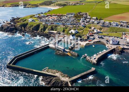 Luftaufnahme zeigt ein Fischerboot, das zum Hafen von St. Abbs an der Küste von Berwickshire, Schottland, Großbritannien, zurückkehrt. Stockfoto