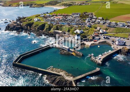 Luftaufnahme zeigt ein Fischerboot, das zum Hafen von St. Abbs an der Küste von Berwickshire, Schottland, Großbritannien, zurückkehrt. Stockfoto