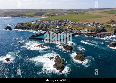 Luftaufnahme zeigt ein Fischerboot, das zum Hafen von St. Abbs an der Küste von Berwickshire, Schottland, Großbritannien, zurückkehrt. Stockfoto