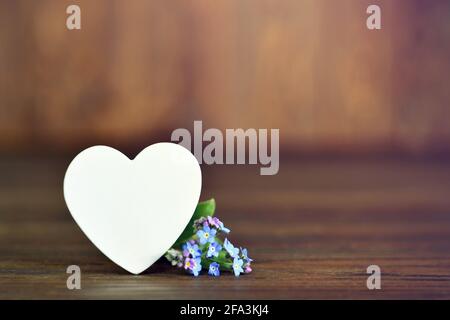 Muttertagskarte mit Herz und Blumen auf Holzhintergrund Stockfoto