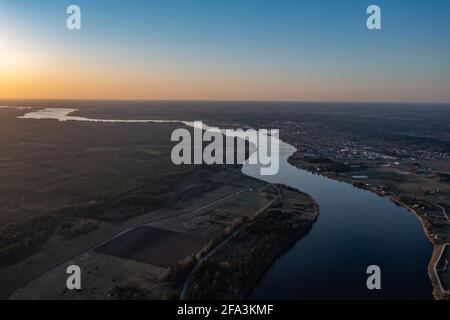 Draufsicht auf den Fluss, umgeben von Bäumen und Wiesen an seinen Ufern, Blick von oben - Luftaufnahme Stockfoto