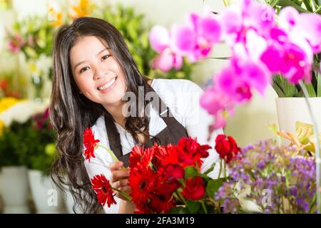 Freundliche asiatische Floristin oder Verkäuferin in einem Blumenladen Stockfoto