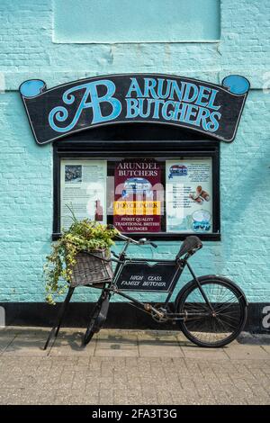 Altmodische Metzgereien Fahrrad und Zeichen auf bunte Wand im Arundel Metzgerladen, Arundel Stadtzentrum, West Sussex, Großbritannien Stockfoto