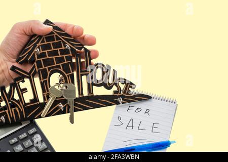 Nahaufnahme eines hölzernen Schlüsselhalters mit zwei isolierten Schlüsseln auf gelbem Hintergrund. Schweden. Stockfoto