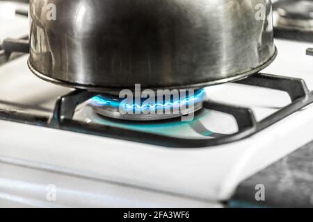 Metallkessel mit Wasser erwärmt sich auf einem Gasherd in Nahaufnahme. Stockfoto