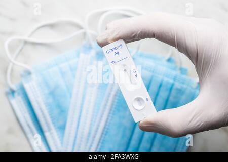 Covid-19 Schnellantigen-Test. Test-Kit für schnelle Antikörper mit Gummihandschuhen in der Hand. Stockfoto