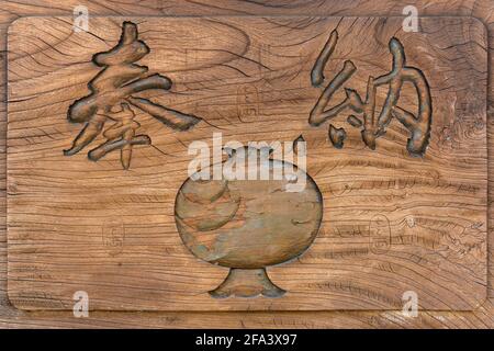 tokio, japan - 07 2021. april: Nahaufnahme auf einem zerrissenen Holzbrett, das mit dem Symbol des magischen Schlägers des Daikokuten-gottes und zwei geschnitzten japanischen Kanas geschmückt ist Stockfoto