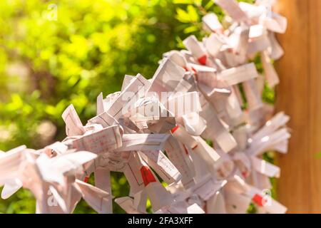 tokio, japan - 20 2021. april: Nahaufnahme von Shinto o-mikuji-Papieren auf einem hölzernen Omikujikake im Atago-Schrein von Tokio. Stockfoto