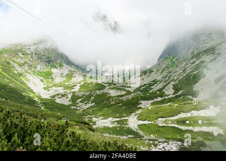 Tal in den Bergen bedeckt mit Wolken. Stockfoto