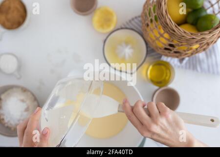 Frau Hände fallen einige Muffin Teig in einer Plastikschale zu schlagen. Stockfoto