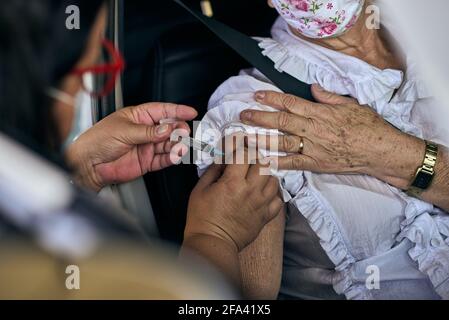 Franca, Brasilien. April 2021. Krankenschwester wendet am 22. April 2021 an einem Drive-Thru in Franca, Sao Paulo, Brasilien, einen Impfstoff gegen Covid-19 an ältere Menschen an. Brasilien hat mindestens die erste Dosis an mehr als 27 Millionen Menschen verabreicht. Das Land hat die höchste Zahl von Todesfällen pro Million Einwohner, die durch das Coronavirus verursacht wurden, mit mehr als 381 Tausend Opfern. (Foto von Igor do Vene/Sipa USA) Quelle: SIPA USA/Alamy Live News Stockfoto