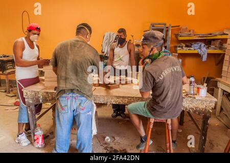 ESTELI, NICARAGUA - 21. APRIL 2016: Arbeiter, die in der Zigarrenfabrik Tabacalera Santiago in Esteli Holzkisten für Zigarren herstellen. Stockfoto