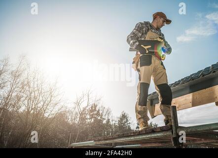 Dachkonstruktion und Keramikfliesen Installation von professionellen kaukasischen Dachdecker in seinen 40er Jahren. Stockfoto