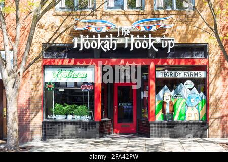 ASHEVILLE, NC, USA-11 APRIL 2021: Front of the Hookah Hook Up, ein Geschäft in der Innenstadt. Sieht aus wie Marihuana, das vor dem Fenster wächst. Stockfoto