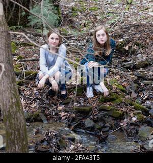 Zwei Mädchen aus der Highschool genießen ihre Freundschaft in der Natur im Wald Stockfoto