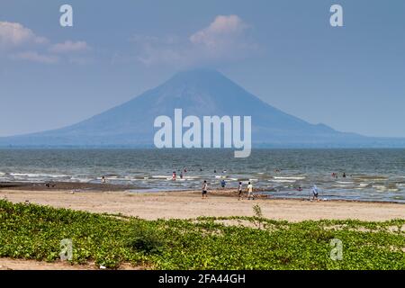 RIVAS, NICARAGUA - 1. MAI 2016: Menschen schwimmen im Lago Cocibolca Nicaragua See in der Nähe von San Jorge Dorf, Nicaragua. Vulkan Concepcion im Hintergrund. Stockfoto