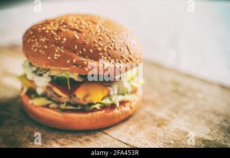 Rustikaler handgemachter Hamburger auf dem Tisch. Stockfoto