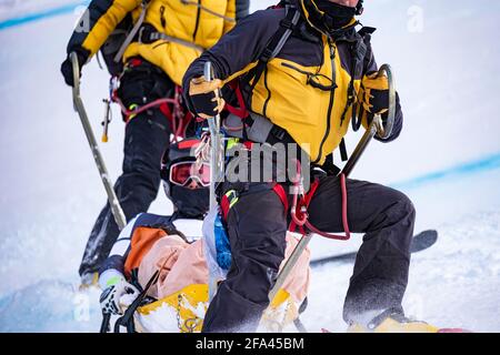 Rettung von Skifahrern auf einer Piste Stockfoto