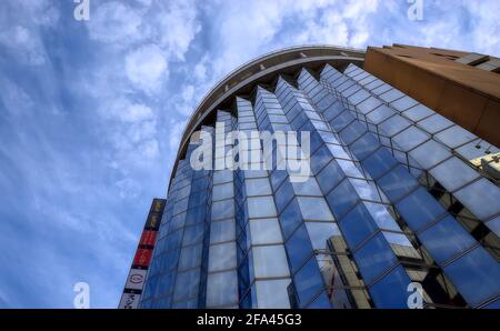 Osaka, Japan - November 5 2020: Blick am Tag auf die verspiegelte Fassade des Amuza-Gebäudes im Zentrum von Osaka unter einem teilweise bewölkten Himmel Stockfoto