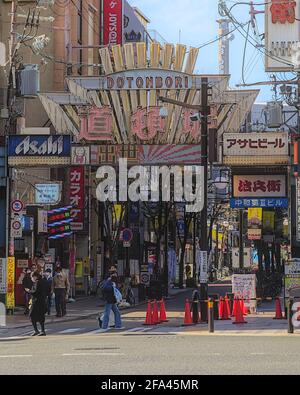 Osaka, Japan - 5 2020. November: Tagesansicht mehrerer Fußgänger, die um einen der Eingänge im Retro-Stil einer Einkaufsstraße im Dotonb herumlaufen Stockfoto