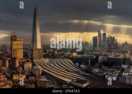 The Shard und London City Skyline mit dem Bahnhof London Bridge. Luftaufnahme von den Bahnlinien direkt nach Sonnenaufgang mit dramatischem Himmel Stockfoto